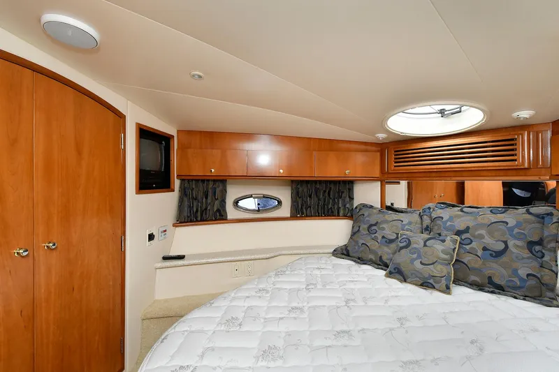 Slide: The Image of Interior of 2001 Carver 466 Motor Yacht bedroom with wood cabinets and plush bedding. - 34