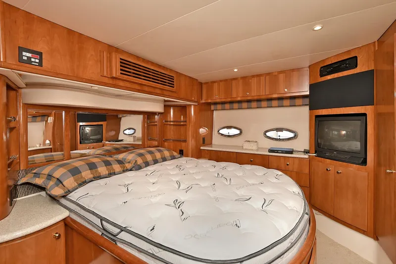 Slide: The Image of Luxurious 2001 Carver 466 Motor Yacht bedroom with wood cabinetry and cozy bedding. - 36