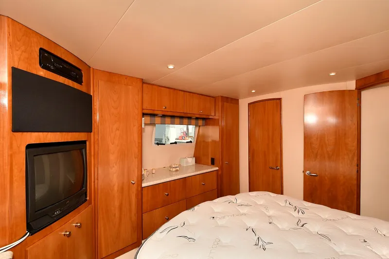 Slide: The Image of Luxurious interior of 2001 Carver 466 Motor Yacht with wood cabinetry and cozy bedding. - 37