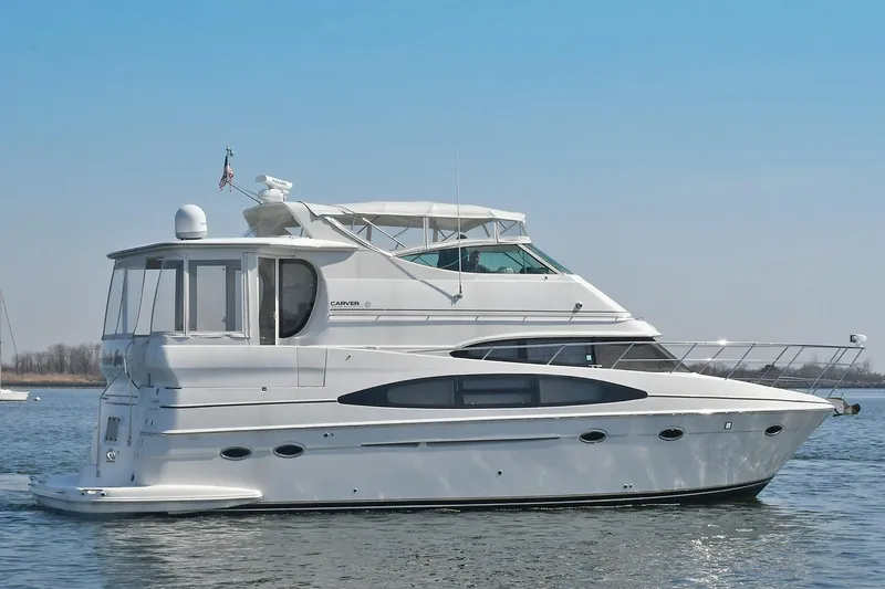 Slide: The Image of 2001 Carver 466 Motor Yacht on calm water under clear blue sky. - 5