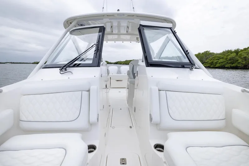 Slide: The Image of 2026 Pursuit DC 286 Dual Console boat interior with white seating and open water view. - 14