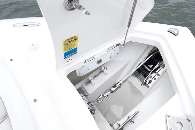 Slide: The Image of 2026 Pursuit DC 286 Dual Console anchor compartment with open hatch, showcasing marine equipment. - 18