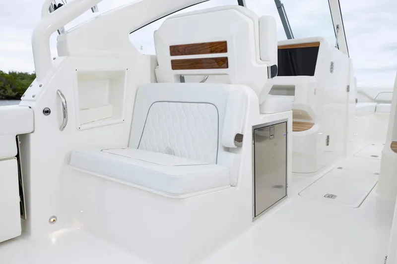 Slide: The Image of 2026 Pursuit DC 286 Dual Console interior with white seating and stainless steel accents. - 7