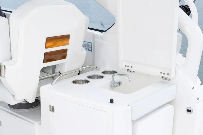 Slide: The Image of 2026 Pursuit DC 286 Dual Console boat interior with sink and seating. - 8