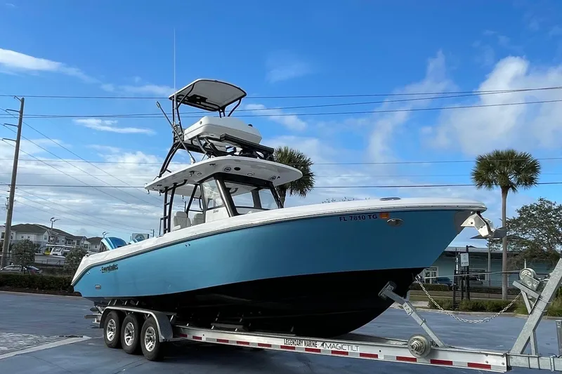 Slide: The Image of 2022 Everglades 335 Center Console boat on trailer under blue sky. - 1