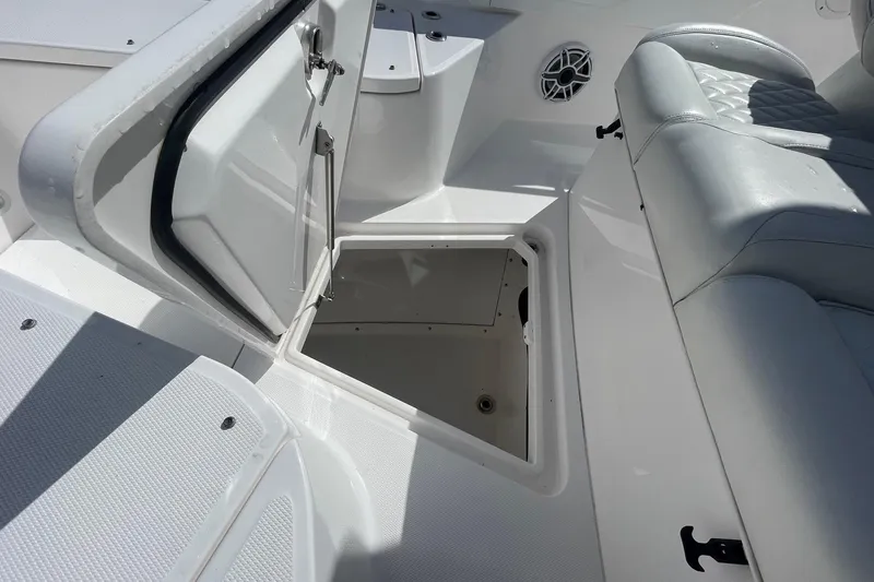 Slide: The Image of 2022 Everglades 335 Center Console boat with open storage compartment and cushioned seating. - 11