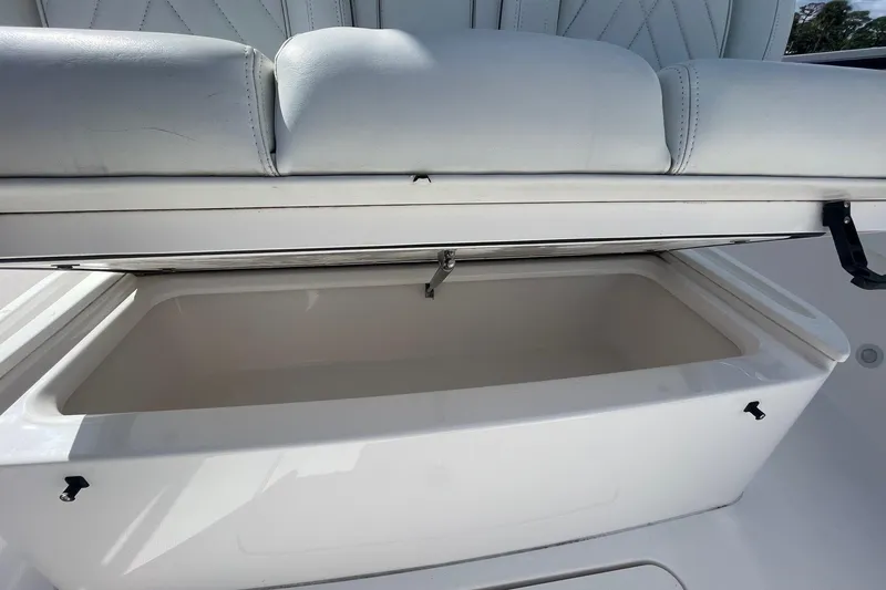 Slide: The Image of 2022 Everglades 335 Center Console storage compartment with cushioned seating. - 15