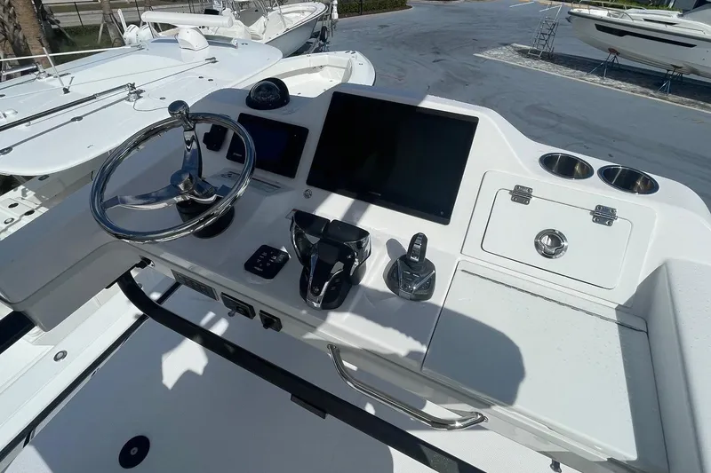 Slide: The Image of 2022 Everglades 335 Center Console boat dashboard with steering wheel and controls. - 18