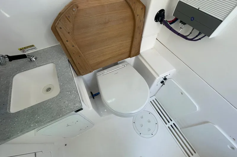 Slide: The Image of 2022 Everglades 335 Center Console boat bathroom with sink and toilet. - 28