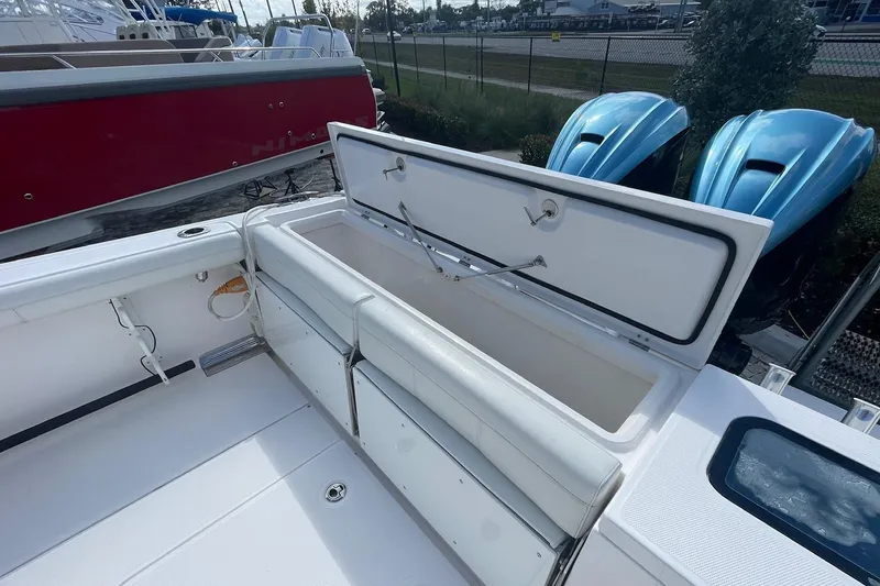 Slide: The Image of 2022 Everglades 335 Center Console boat with open storage compartment and twin blue engines. - 6