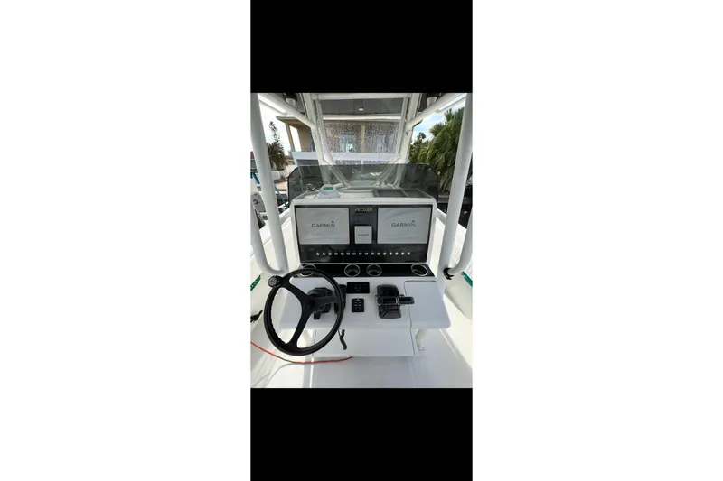 Slide: The Image of 2003 Jupiter 31 boat dashboard with Garmin navigation system and steering wheel. - 11