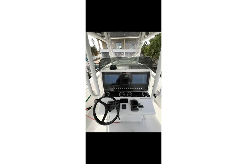 Slide: The Image of 2003 Jupiter 31 boat dashboard with steering wheel and navigation screens. - 12