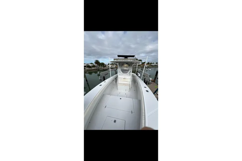 Slide: The Image of 2003 Jupiter 31 boat docked, showcasing spacious deck and sleek design. - 15