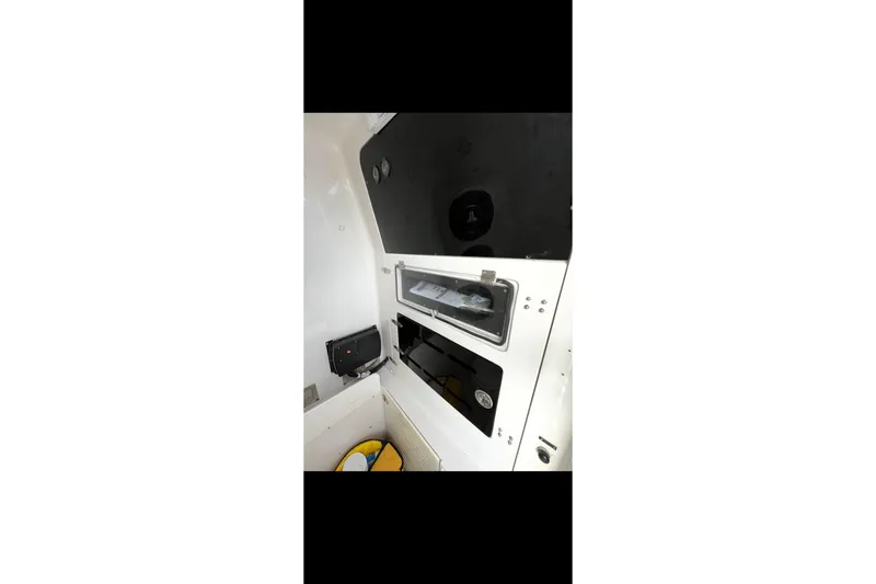Slide: The Image of Interior of a 2003 Jupiter 31 boat, featuring storage compartments and equipment. - 18