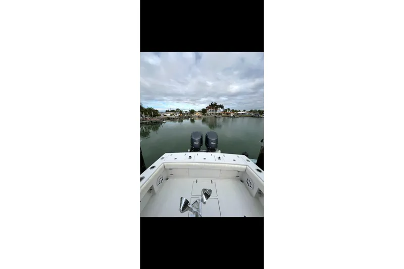 Slide: The Image of 2003 Jupiter 31 boat on calm water with dual engines, overcast sky. - 6