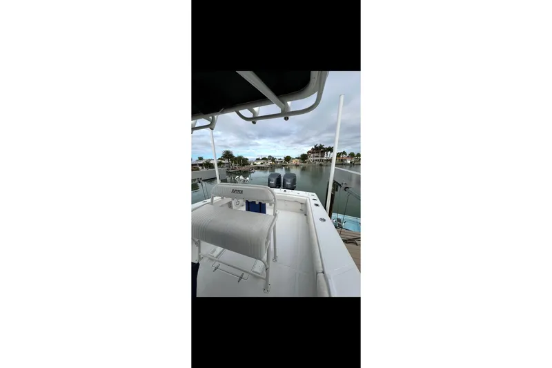 Slide: The Image of 2003 Jupiter 31 boat docked by waterfront homes under cloudy sky. - 8