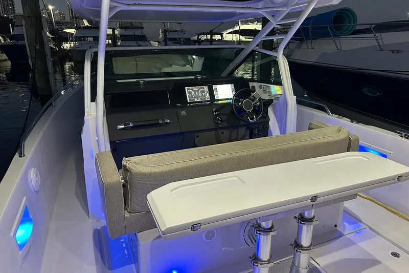 Slide: The Image of 2024 Axopar 37 Sun-Top boat interior with illuminated dashboard and seating area. - 17