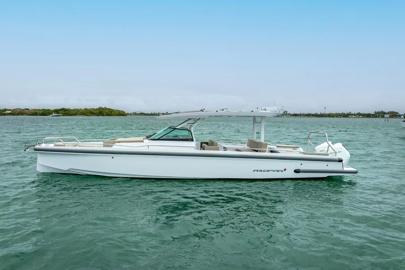 Slide: The Image of 2024 Axopar 37 Sun-Top boat on calm water, showcasing sleek design and modern features. - 5