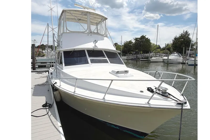 The Image of 1974 Bertram 35 Convertible yacht docked at marina under cloudy sky. - 1
