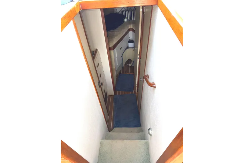 Slide: The Image of Interior view of 1974 Bertram 35 Convertible yacht, featuring a narrow hallway and stairs. - 15