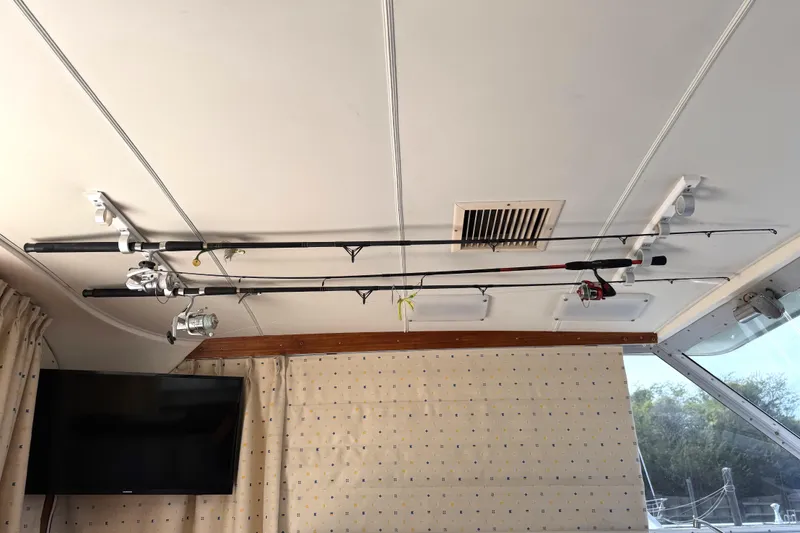 Slide: The Image of Fishing rods mounted on the ceiling of a 1974 Bertram 35 Convertible boat interior. - 16