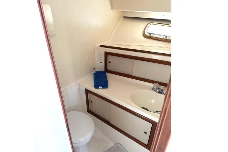 Slide: The Image of 1974 Bertram 35 Convertible yacht bathroom with sink, toilet, and storage cabinets. - 21