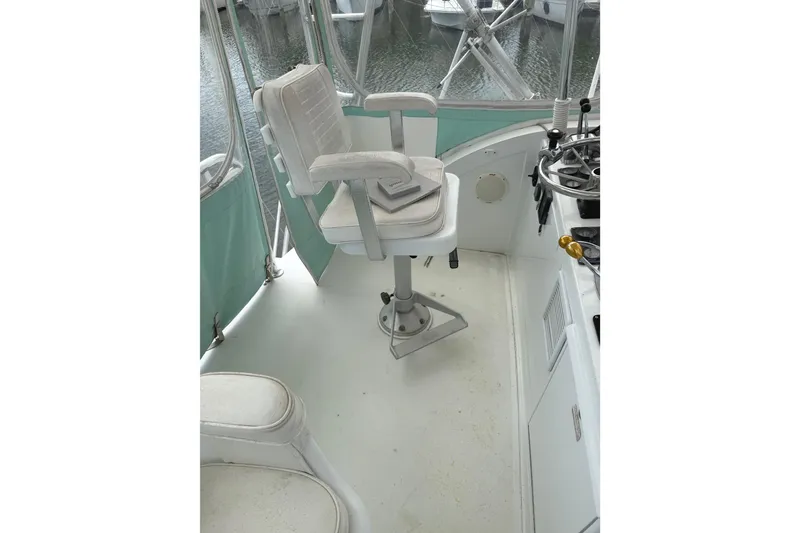 Slide: The Image of 1974 Bertram 35 Convertible boat helm with white captain's chair and steering controls. - 27