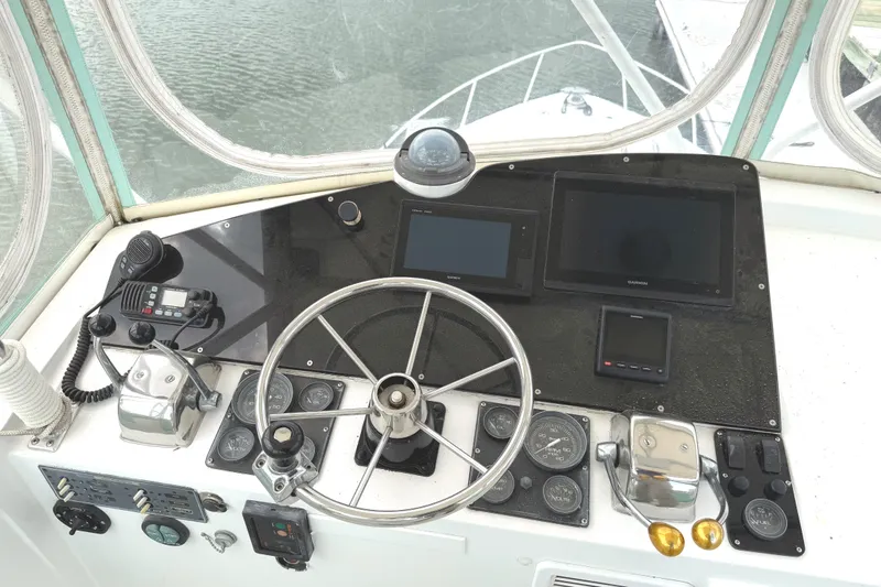 Slide: The Image of 1974 Bertram 35 Convertible helm with steering wheel, gauges, and navigation equipment. - 29