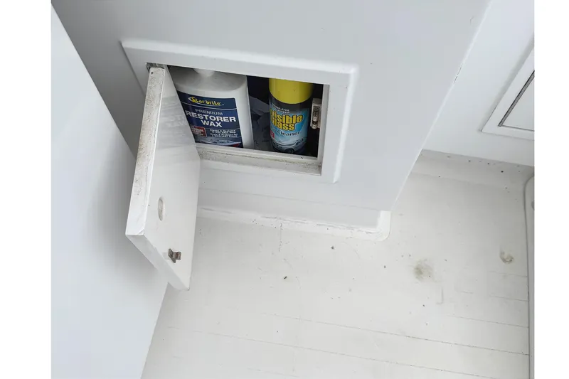 Slide: The Image of Open storage compartment on a 1974 Bertram 35 Convertible boat with cleaning supplies. - 31