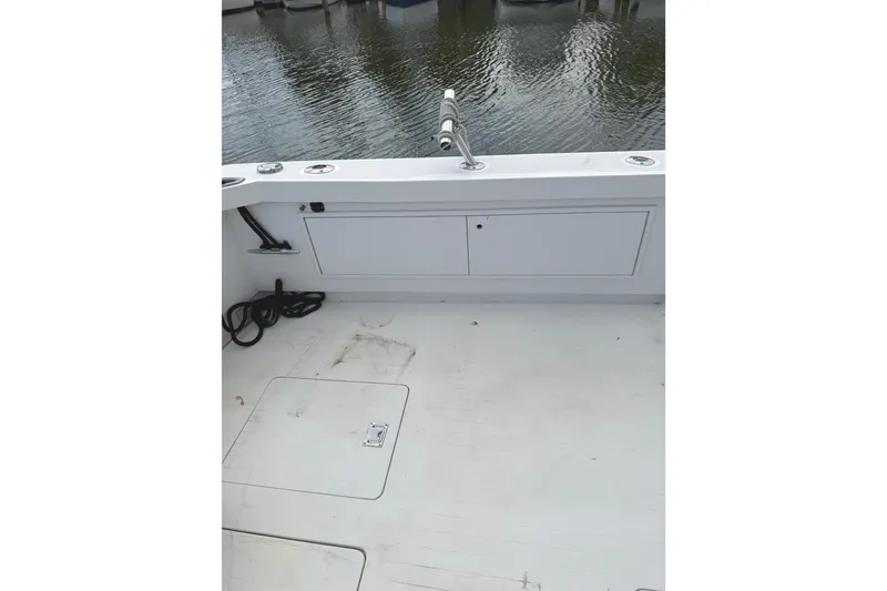 Slide: The Image of 1974 Bertram 35 Convertible boat deck with storage compartments and water view. - 33