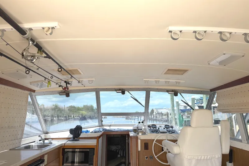 Slide: The Image of Interior view of a 1974 Bertram 35 Convertible boat with fishing rods and helm. - 6