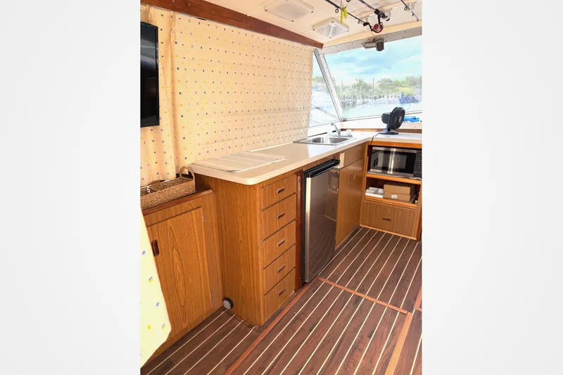 Slide: The Image of Interior of a 1974 Bertram 35 Convertible boat with wooden cabinetry and modern appliances. - 7
