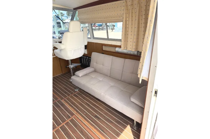 Slide: The Image of 1974 Bertram 35 Convertible interior with beige seating and wood flooring. - 8