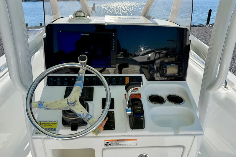 Slide: The Image of Helm of 2017 Sea Hunt Triton 225 with steering wheel and navigation controls. - 15