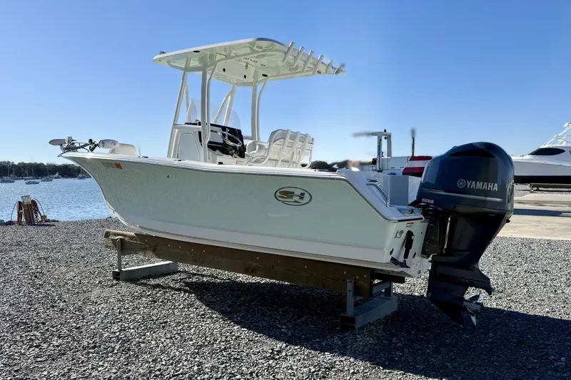Slide: The Image of 2017 Sea Hunt Triton 225 boat with Yamaha outboard motor on gravel near water. - 5