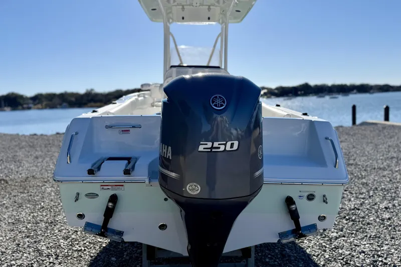 Slide: The Image of 2017 Sea Hunt Triton 225 boat with Yamaha 250 engine, docked by a scenic lake. - 6