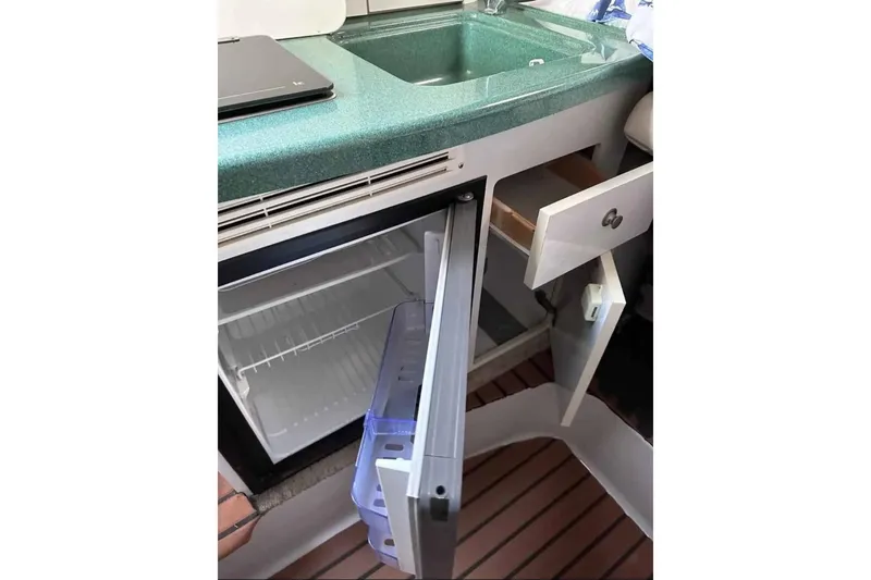 Slide: The Image of Compact kitchenette in 2000 Four Winns 268 Vista boat with open fridge and sink. - 13