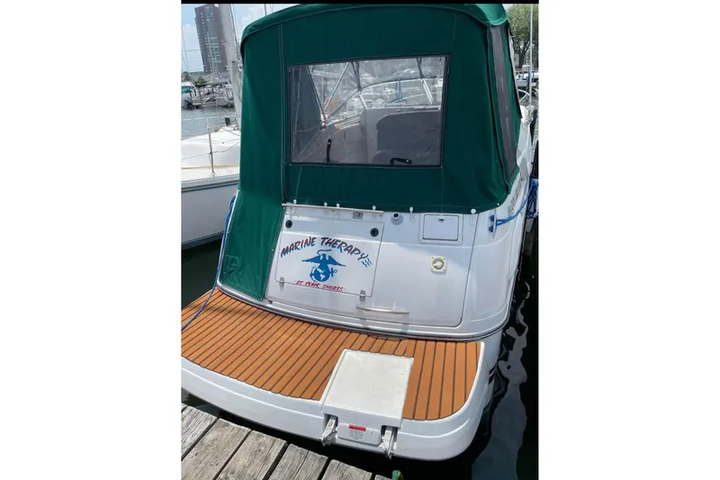 Slide: The Image of 2000 Four Winns 268 Vista boat with green canopy, docked at marina. - 2