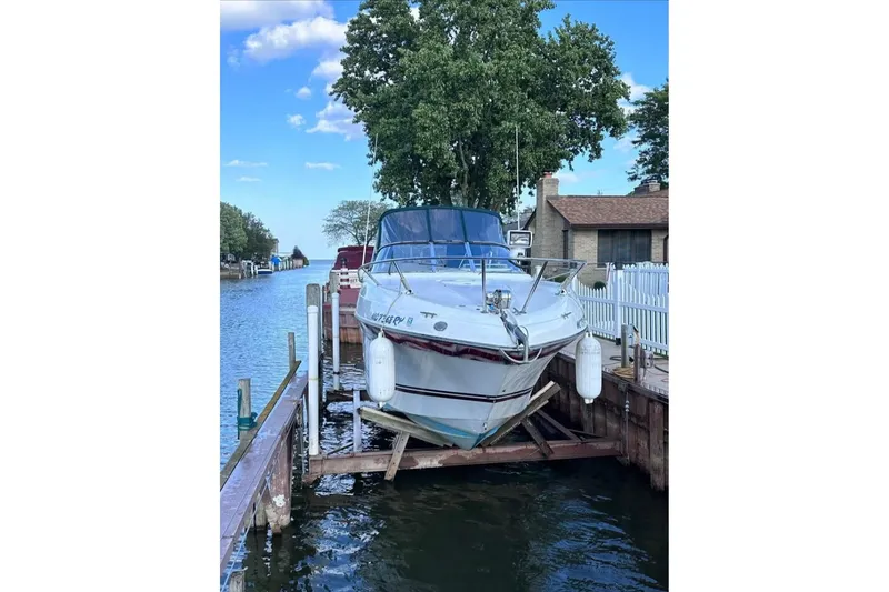 Slide: The Image of 2000 Four Winns 268 Vista boat docked by a scenic waterfront. - 3