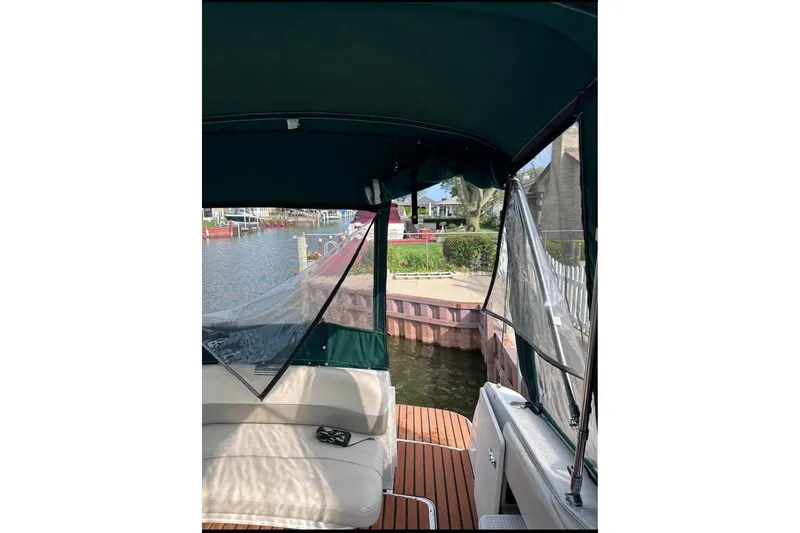 Slide: The Image of 2000 Four Winns 268 Vista boat interior with canopy, docked by waterfront. - 8