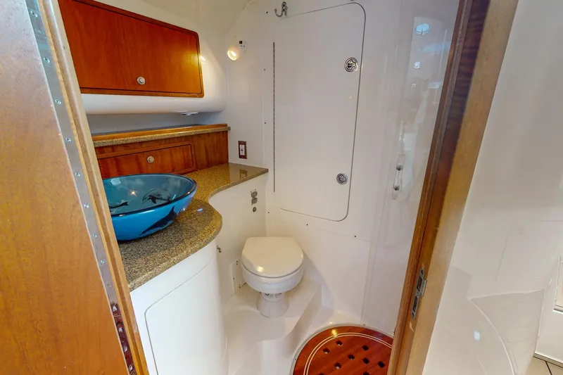 Slide: The Image of 2007 Midnight Express 37 Cabin bathroom with modern sink and wooden cabinetry. - 12