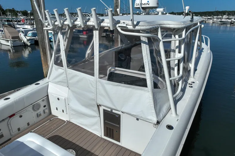 Slide: The Image of 2007 Midnight Express 37 Cabin boat docked in marina, featuring enclosed cabin and fishing rod holders. - 13