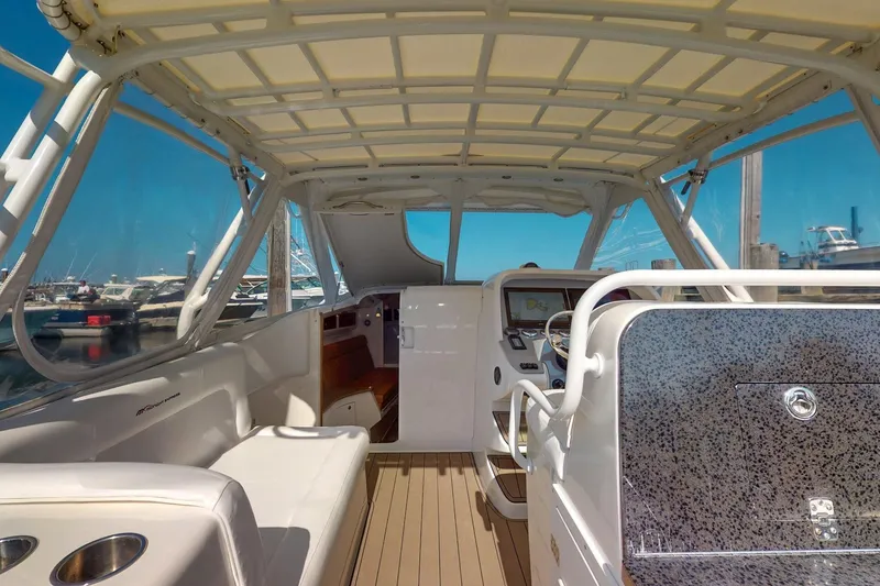 Slide: The Image of 2007 Midnight Express 37 Cabin boat interior with helm, seating, and marina view. - 7