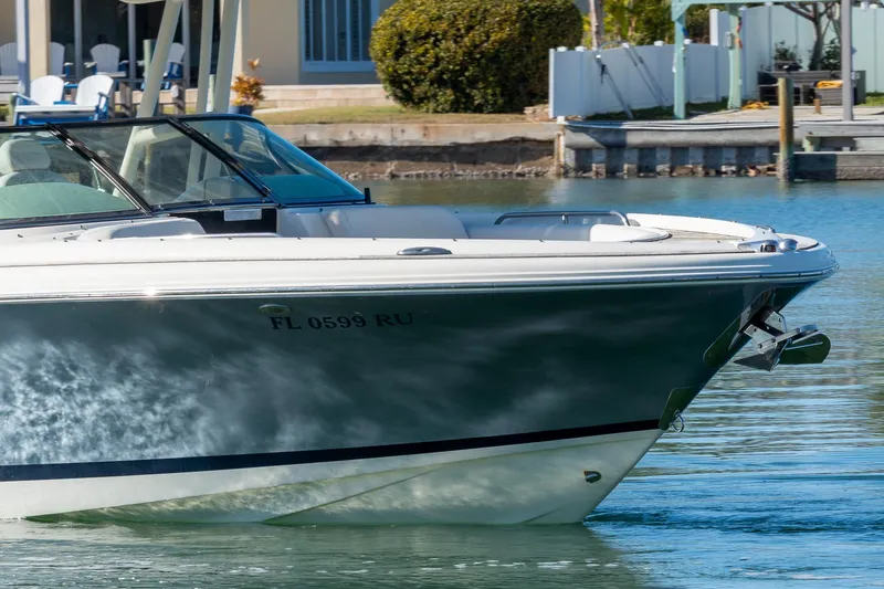 Slide: The Image of 2018 Chris-Craft Calypso 26 boat on calm water near a dock. - 13