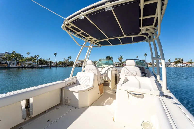 Slide: The Image of 2018 Chris-Craft Calypso 26 boat interior with seating, canopy, and scenic waterfront view. - 15