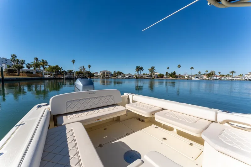 Slide: The Image of 2018 Chris-Craft Calypso 26 boat on calm water with palm trees in the background. - 17