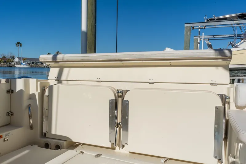 Slide: The Image of 2018 Chris-Craft Calypso 26 boat interior with storage compartments, docked by calm waters. - 23