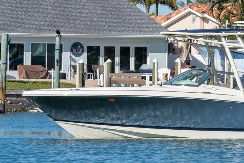 Slide: The Image of 2018 Chris-Craft Calypso 26 boat on water near waterfront home. - 3