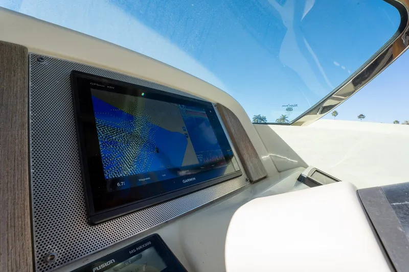 Slide: The Image of 2018 Chris-Craft Calypso 26 dashboard with Garmin GPS display under clear blue sky. - 30