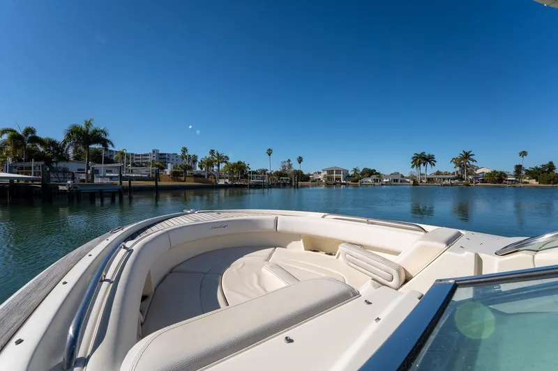 Slide: The Image of 2018 Chris-Craft Calypso 26 boat on serene water with palm trees and clear sky. - 35